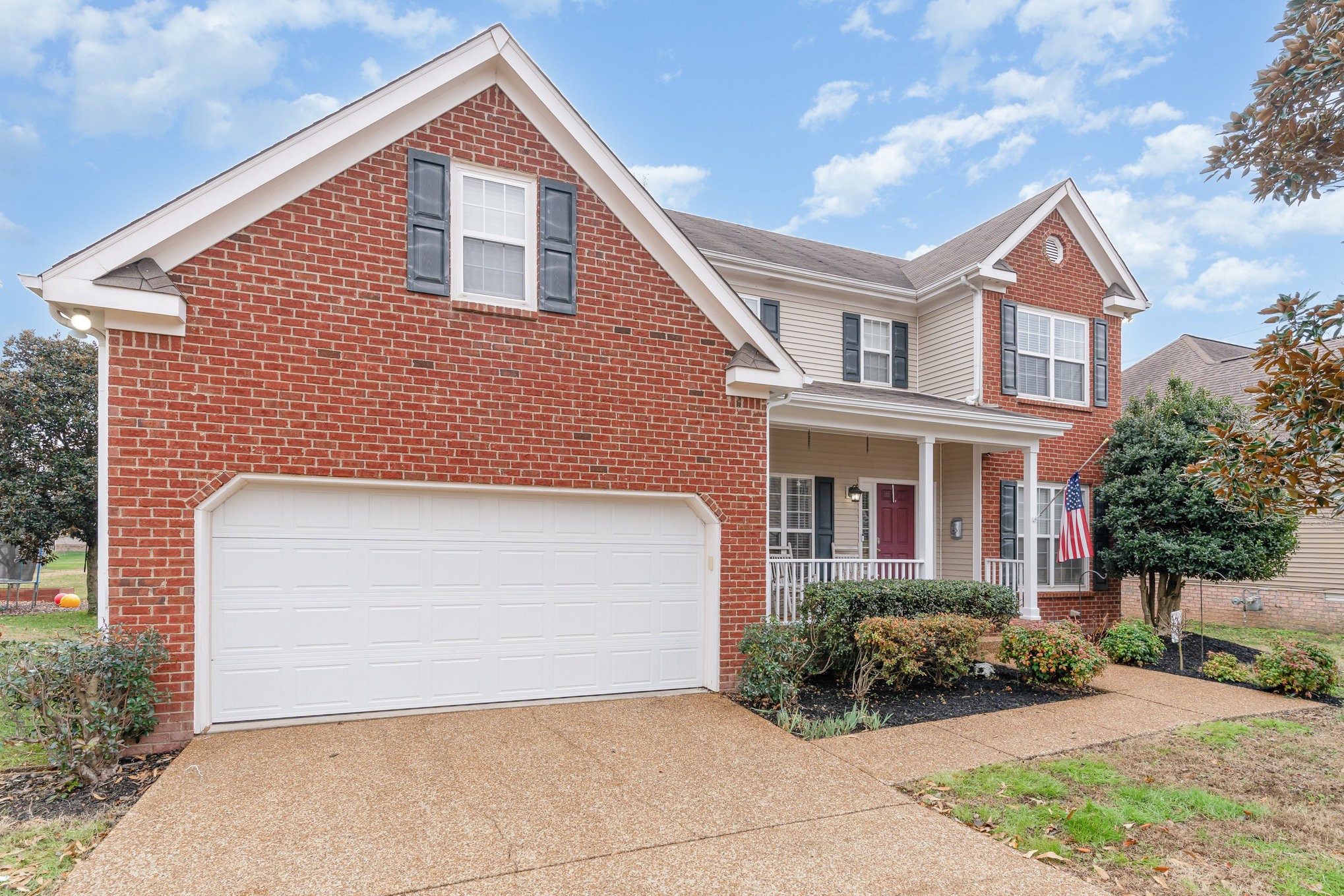2261 Dewey Drive Spring Hill, TN 37174 - Photo 3 of 26 a view of a brick house with a yard plants and large tree