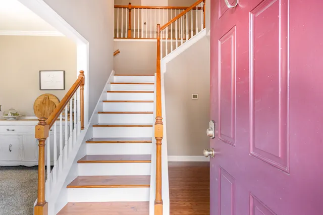 a view of staircase with lots of frames on wall and a window