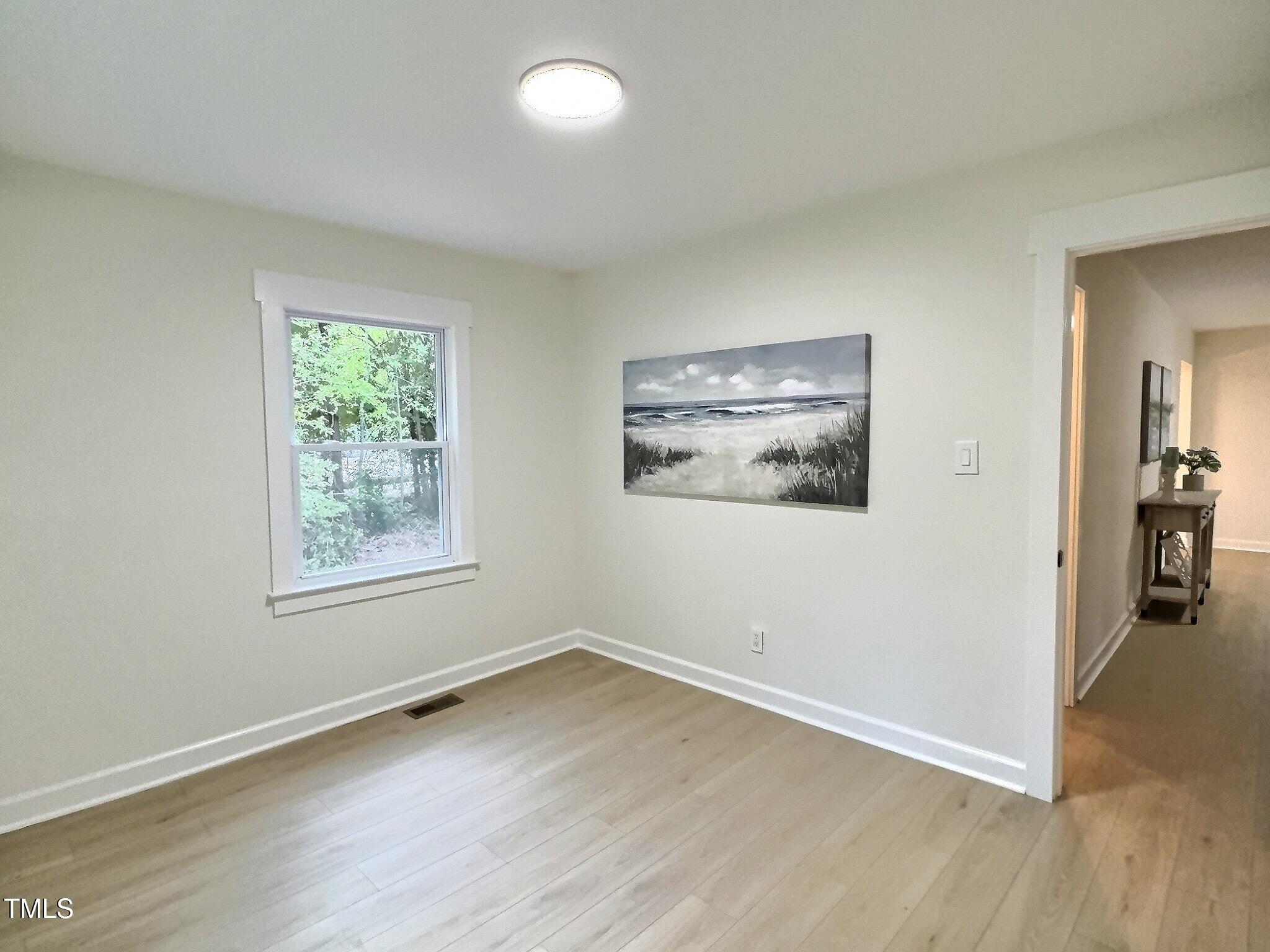 116 Lumpkin Street Raleigh, NC 27610 - Photo 13 of 20 an empty room with wooden floor and windows