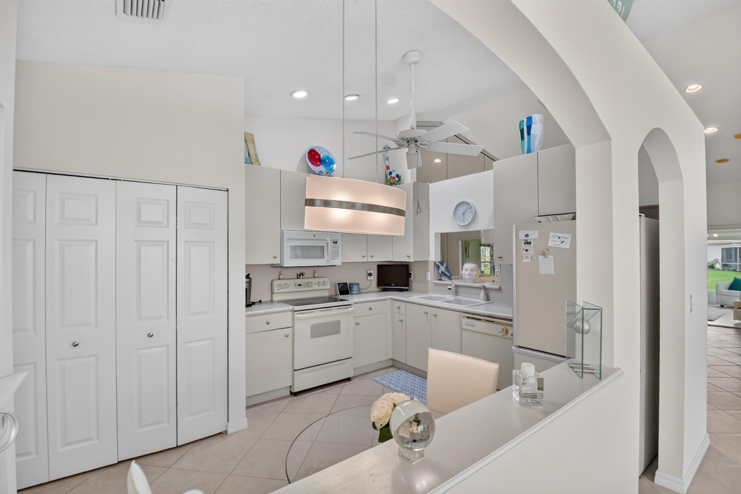 15340 Floral Club Road Delray Beach, FL 33484 - Photo 8 of 42 a large white kitchen with cabinets and stainless steel appliances