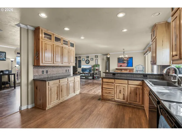 a kitchen with stainless steel appliances granite countertop wooden cabinets a sink dishwasher a stove and a refrigerator