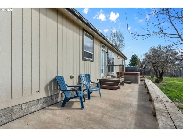 a backyard of a house with table and chairs