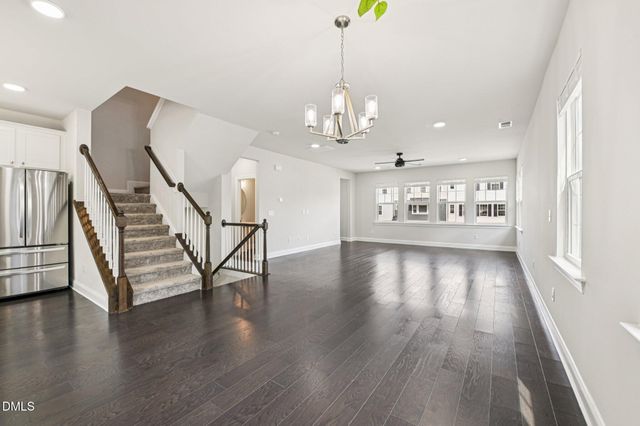 a view of a room with wooden floor staircase and a kitchen