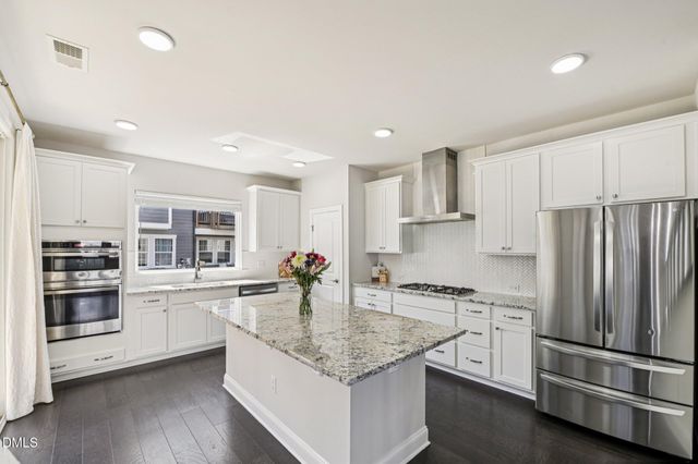 a kitchen with stainless steel appliances granite countertop a refrigerator sink and stove