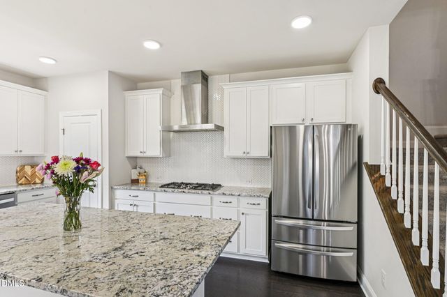 a kitchen with white cabinets and appliances