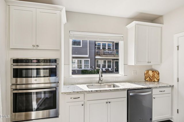 a kitchen with stainless steel appliances a sink stove and cabinets