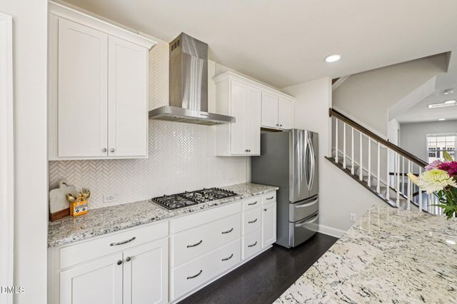 a kitchen with granite countertop a white cabinets and stainless steel appliances