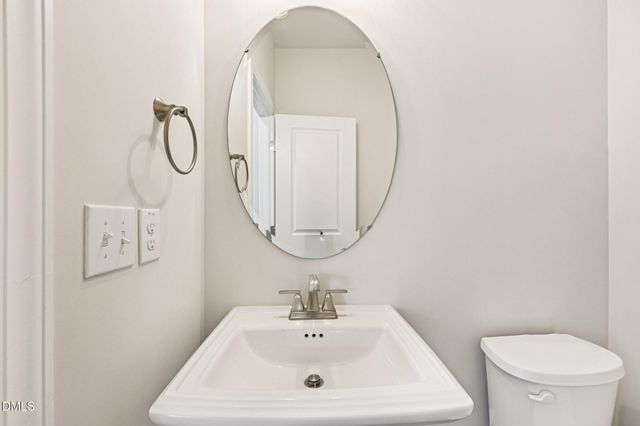a bathroom with a sink mirror and toilet