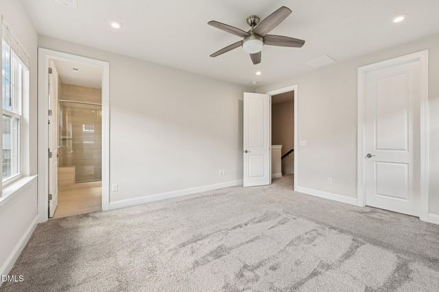 an empty room with closet and a ceiling fan