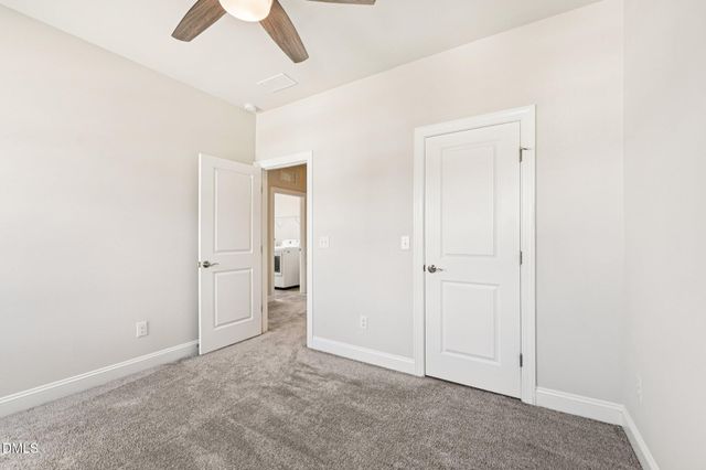 an empty room with chandelier fan