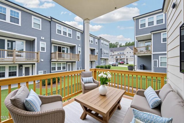 a view of a patio with couches chairs and wooden floor