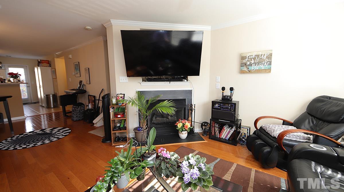 9818 Grettle Court Raleigh, NC 27617 - Photo 4 of 14 a living room with furniture fireplace and flat screen tv