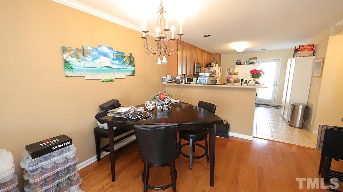 9818 Grettle Court Raleigh, NC 27617 - Photo 5 of 14 a dining room with furniture and a chandelier