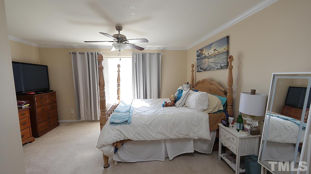 9818 Grettle Court Raleigh, NC 27617 - Photo 9 of 14 a bedroom with a bed and a flat screen tv