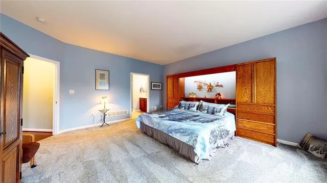 a spacious bedroom with a bed and large windows