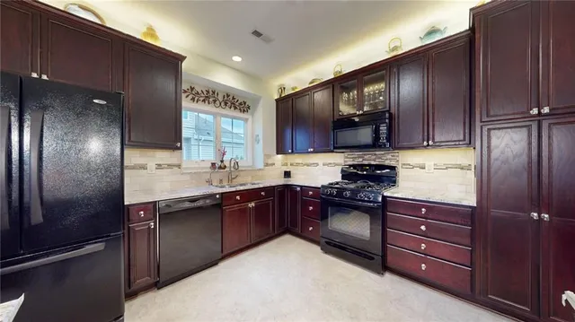 a kitchen with stainless steel appliances granite countertop wooden cabinets a stove top oven a sink and dishwasher