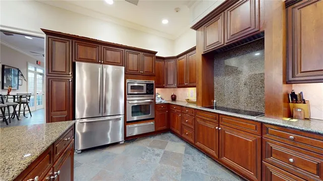 a kitchen with granite countertop a refrigerator and cabinets