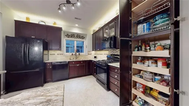 a kitchen with stainless steel appliances granite countertop a refrigerator and a wooden cabinets