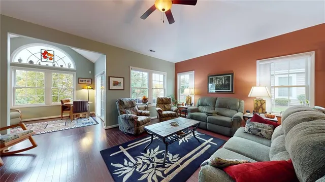 a living room with furniture wooden floor and a large window