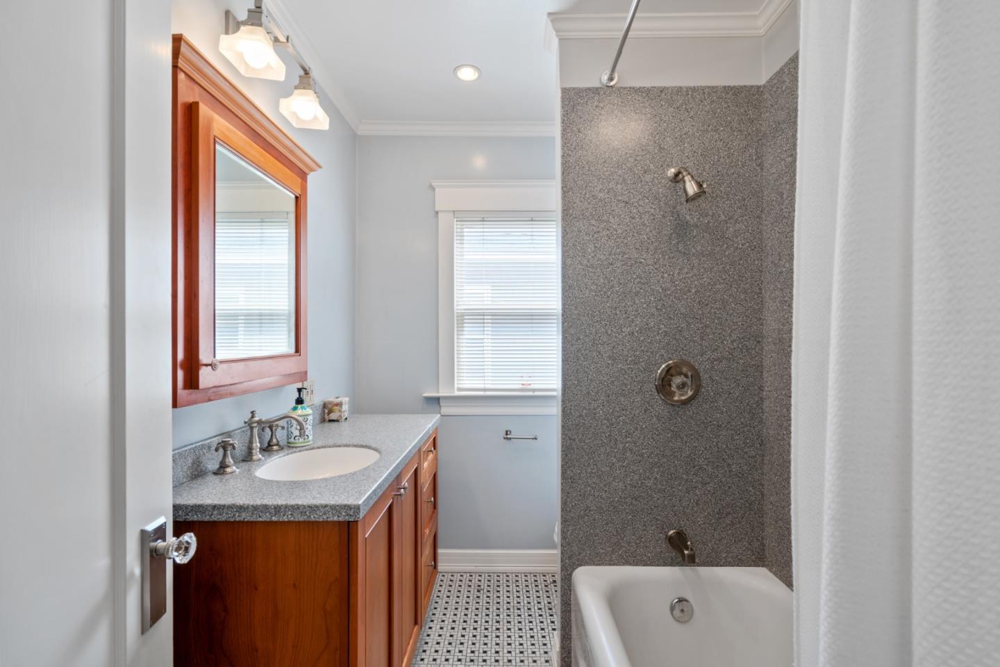 142 16th Avenue San Mateo, CA 94402 - Photo 14 of 25 a bathroom with a granite countertop sink a shower and a mirror