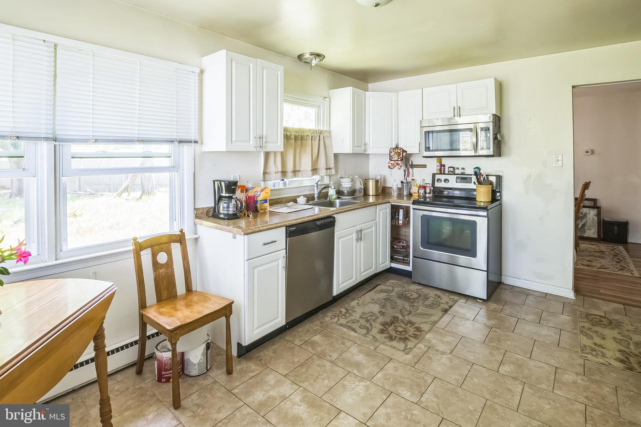 9 Queens Way Newark, DE 19713 - Photo 12 of 28 a kitchen with stainless steel appliances granite countertop a stove top oven a sink dishwasher and a refrigerator