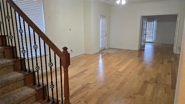 a view of a hallway with wooden floor and staircase