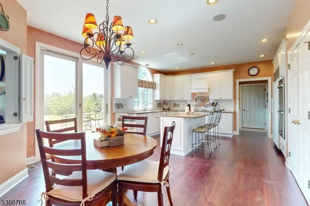 a dining room with furniture a large window and wooden floor