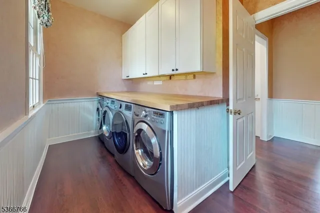 a utility room with wooden floor washer and dryer