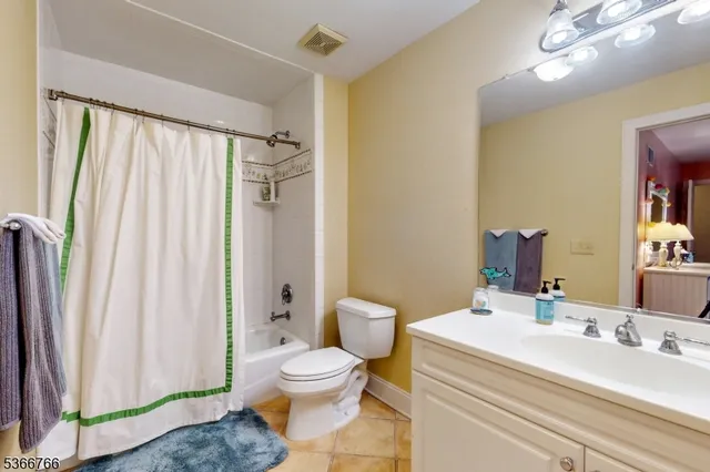 a bathroom with a sink a toilet and shower curtain