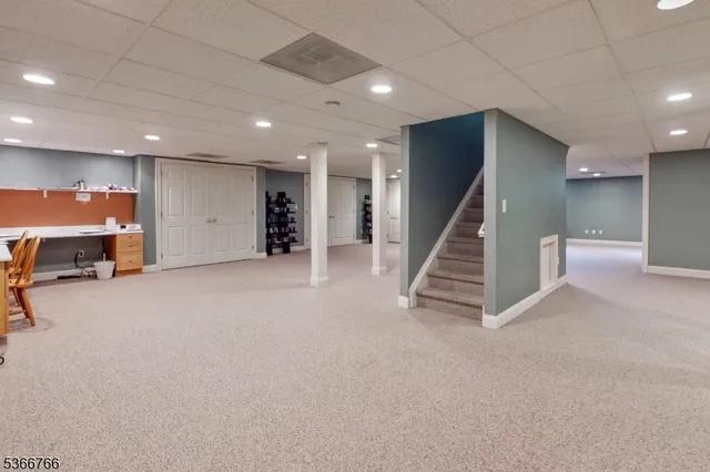 an empty room with wooden floor and stairs