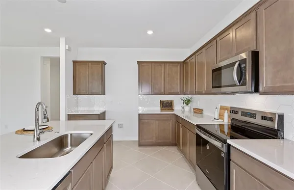 a kitchen with a sink a stove and cabinets