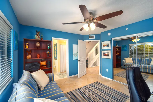 a view of staircase with lots of frames on wall and a view of a hallway