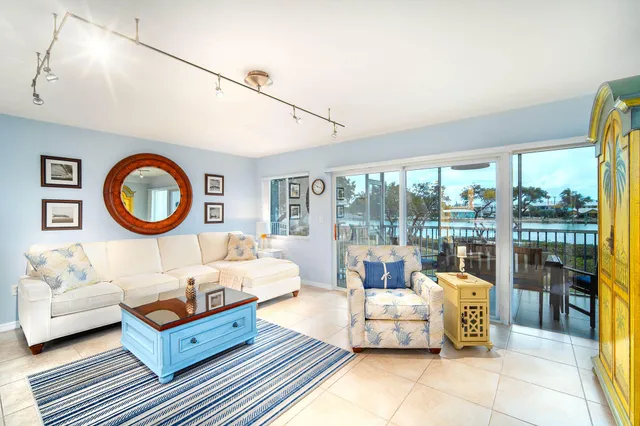 a living room with furniture a flat screen tv and a floor to ceiling window