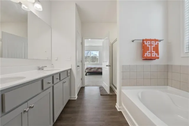 a bathroom with a tub a sink and mirror