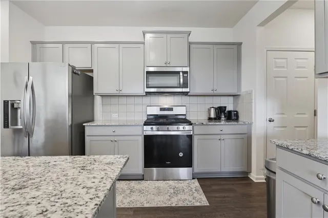 a kitchen with stainless steel appliances granite countertop a stove a refrigerator and a sink