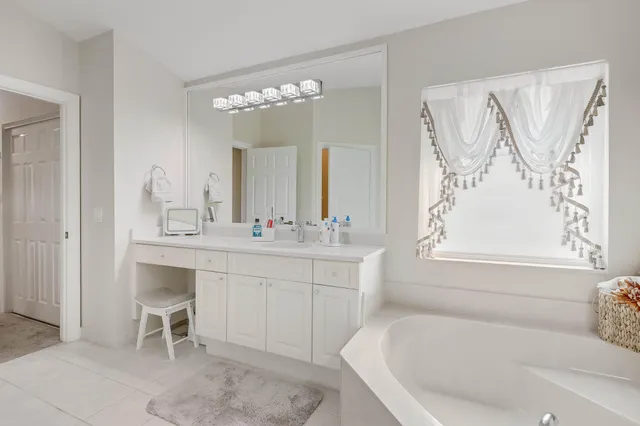 a bathroom with a tub sink and mirror