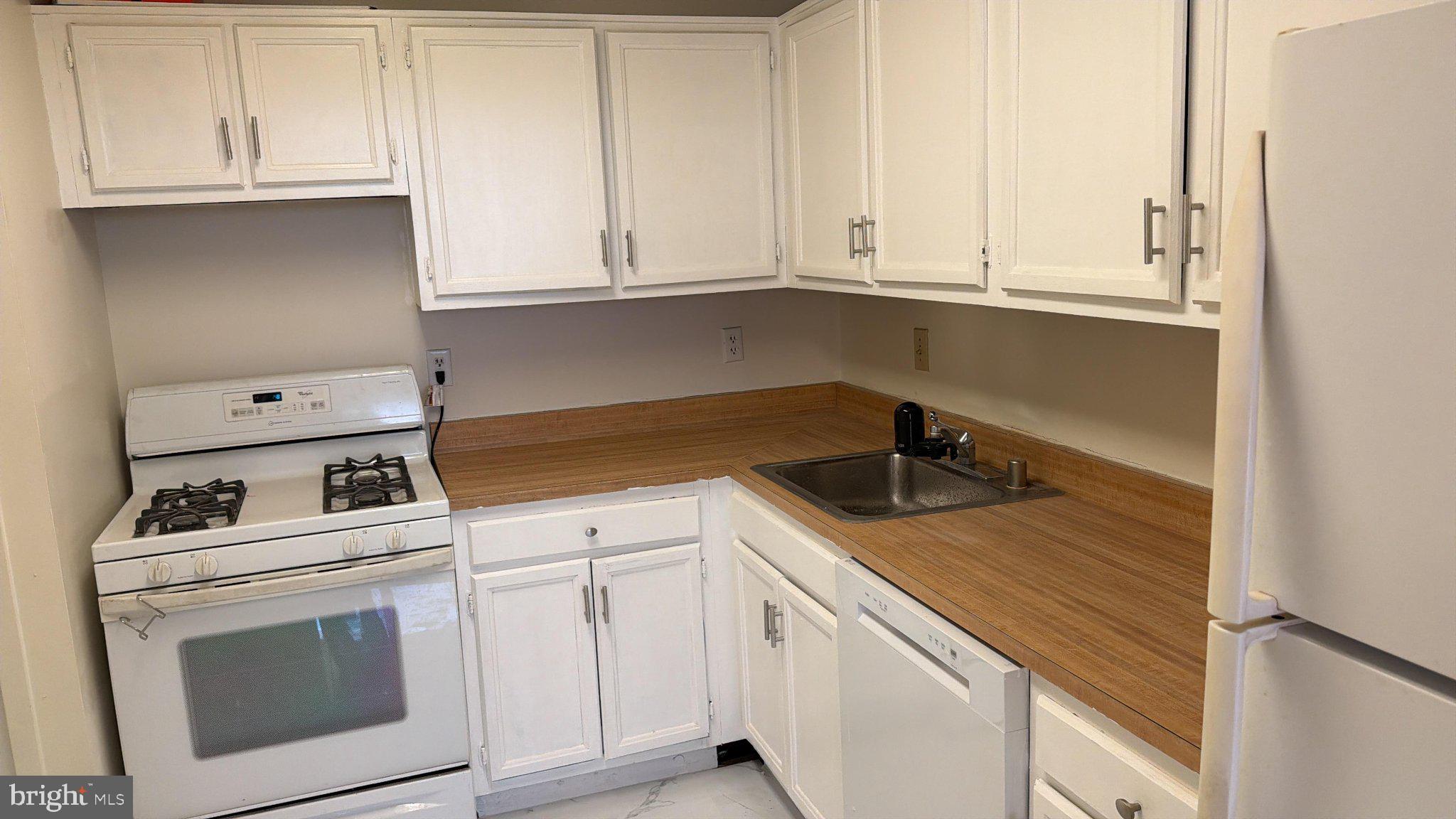 5225 Pooks Hill Road, Unit 1211S Bethesda, MD 20814 - Photo 22 of 36 a kitchen with white cabinets and white appliances
