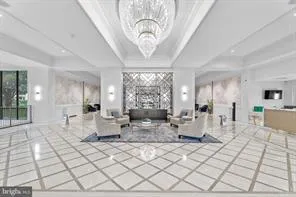 a living room with furniture a large window and chandelier