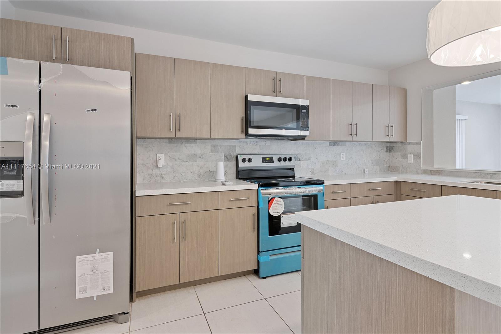 1960 Southwest 51st Terrace Plantation, FL 33317 - Photo 15 of 35 a kitchen with stainless steel appliances a refrigerator sink and cabinets