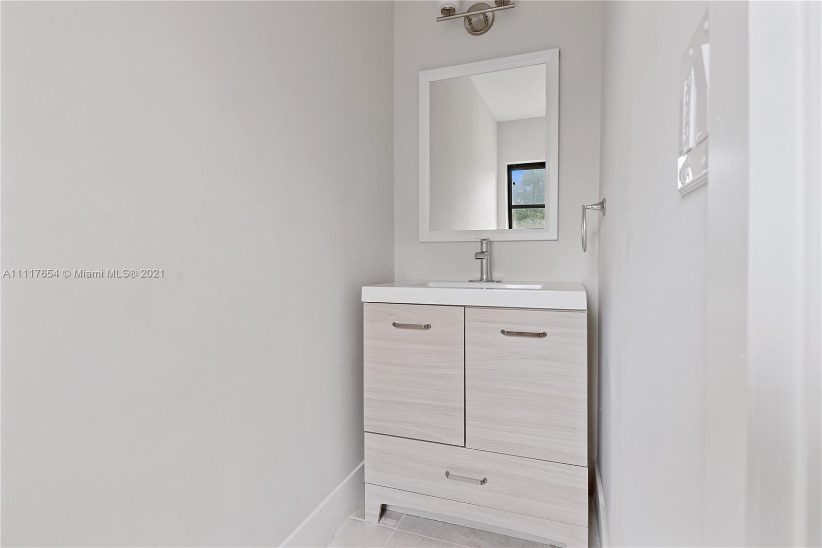 1960 Southwest 51st Terrace Plantation, FL 33317 - Photo 17 of 35 a bathroom with a sink vanity and mirror