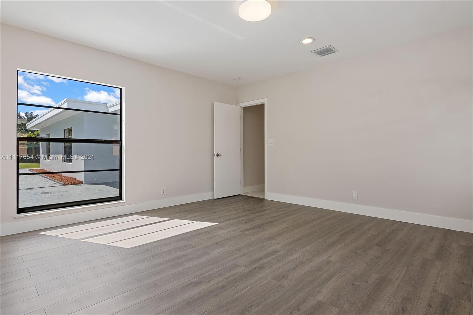 1960 Southwest 51st Terrace Plantation, FL 33317 - Photo 19 of 35 an empty room with wooden floor and windows