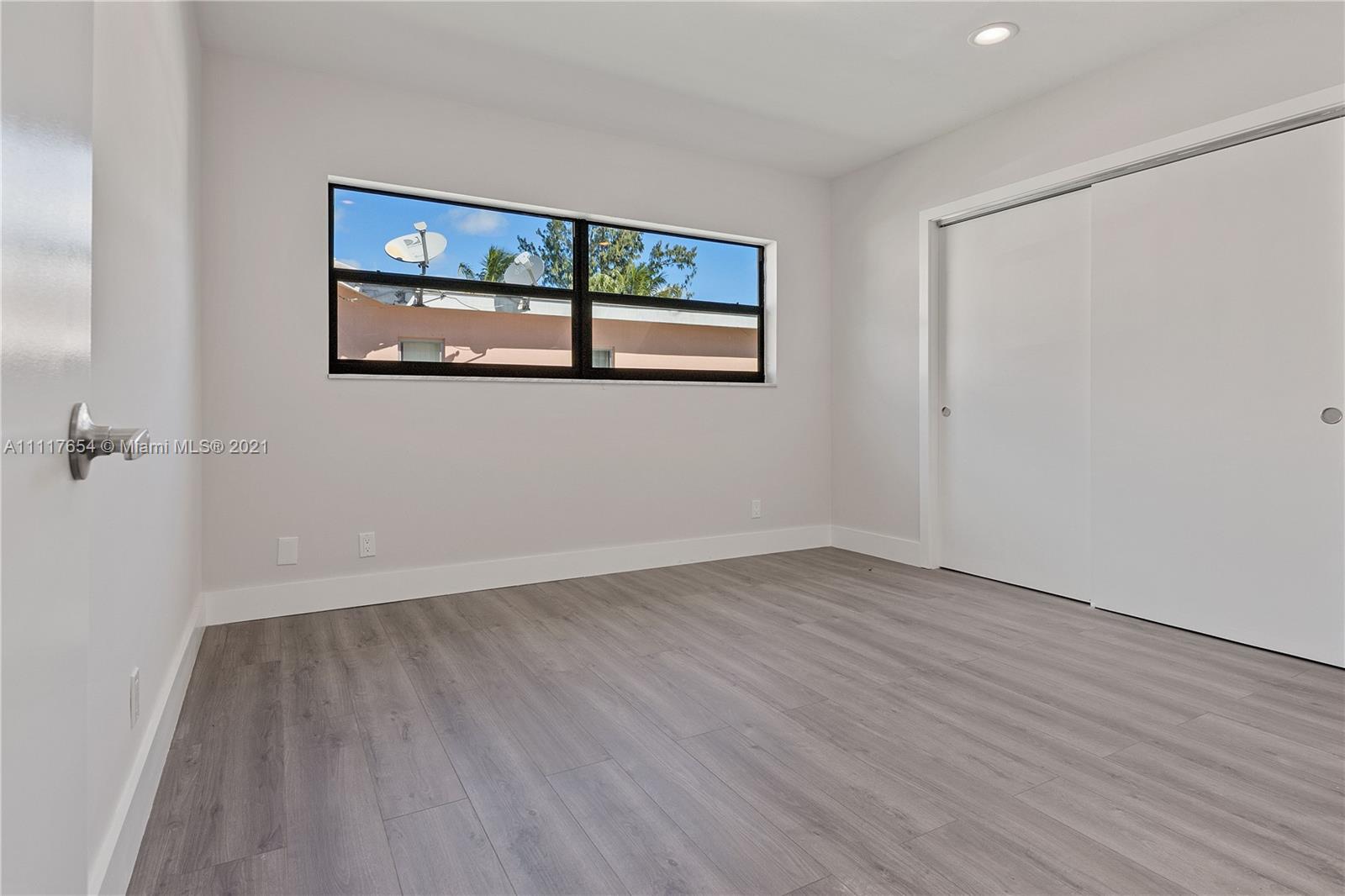 1960 Southwest 51st Terrace Plantation, FL 33317 - Photo 25 of 35 a view of an empty room with wooden floor and a window
