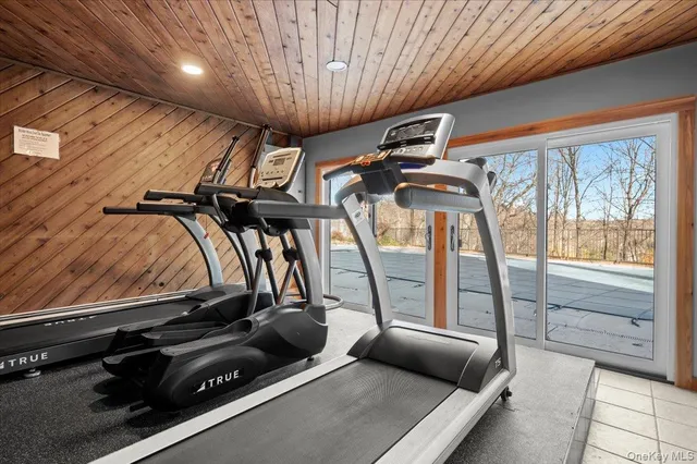 a room with gym equipment and large windows