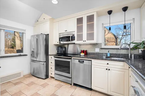 a kitchen with stainless steel appliances granite countertop a refrigerator sink and stove