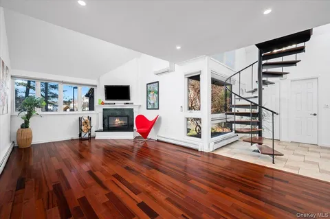 a view of a livingroom with wooden floor and a ceiling fan