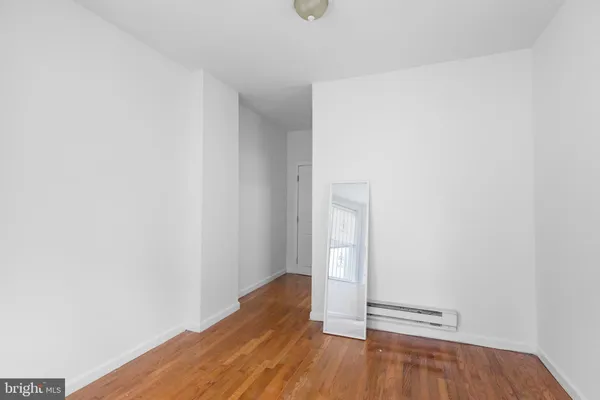 a view of a small space with wooden floor and a window