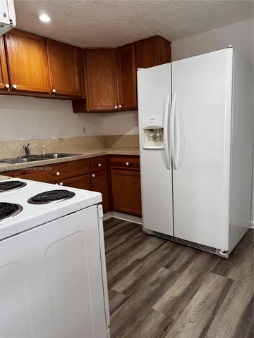 a kitchen with a refrigerator sink and cabinets