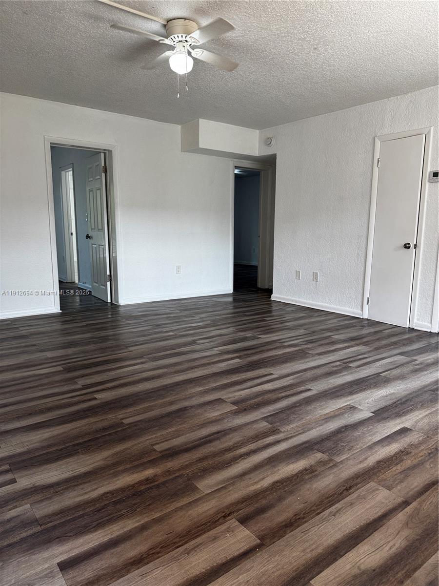 1330 West 54th Street, Unit 205C Hialeah, FL 33012 - Photo 4 of 10 a view of an empty room with wooden floor and chandelier fan