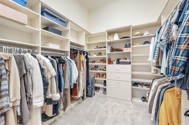 a view of walk in closet with clothes and shoes