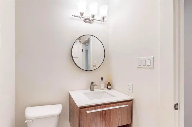 a bathroom with a sink a toilet and a mirror